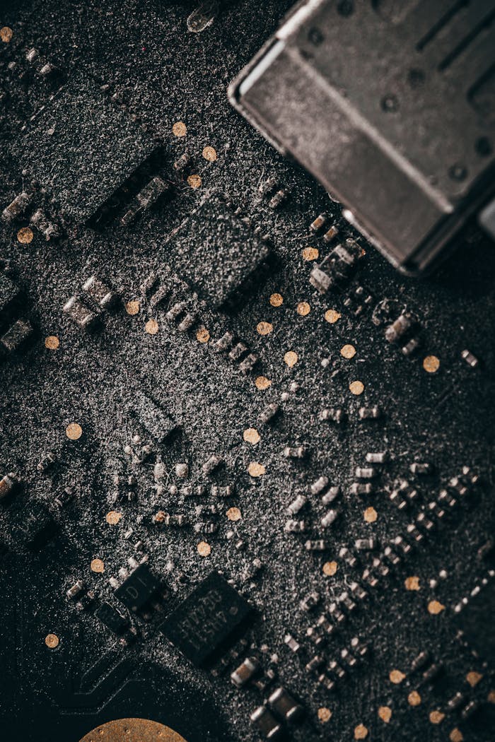 Macro shot of a dusty computer circuit board with intricate components and connectors.
