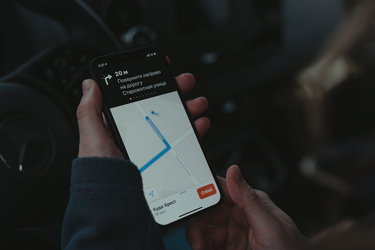 Services Close-up of a smartphone displaying a navigation app in a car, highlighting modern technology use while driving.